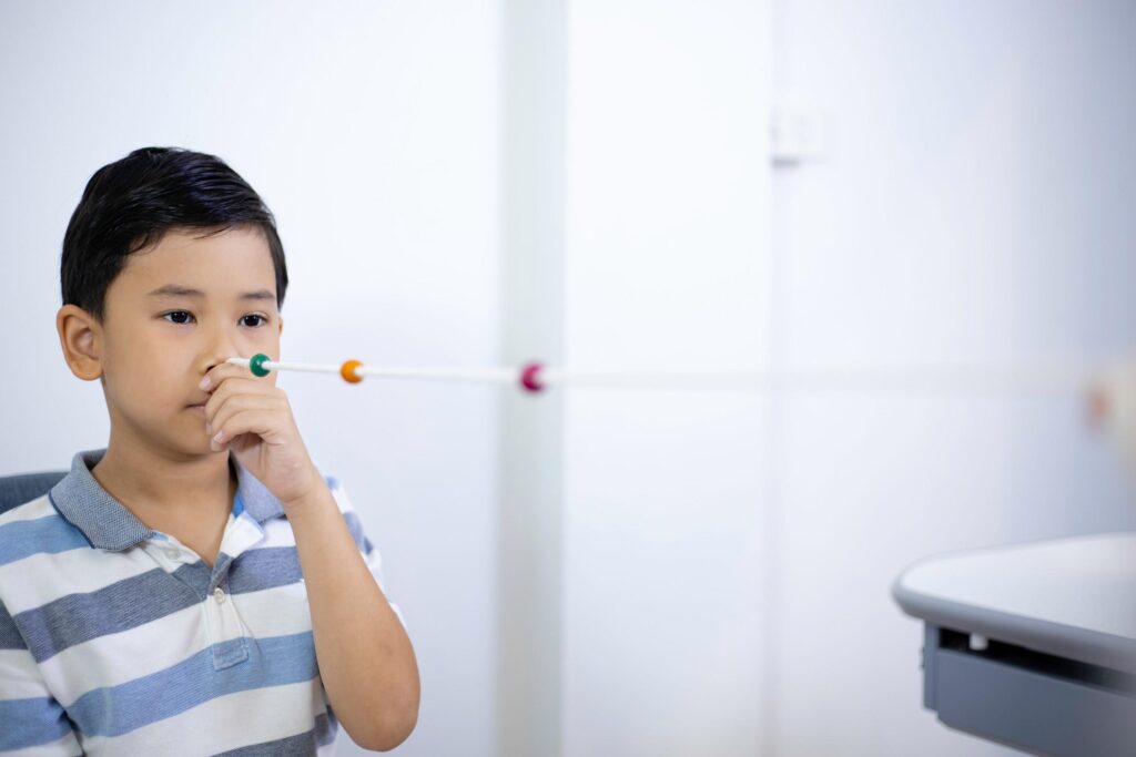 boy-with-string-and-beads-eye-exam