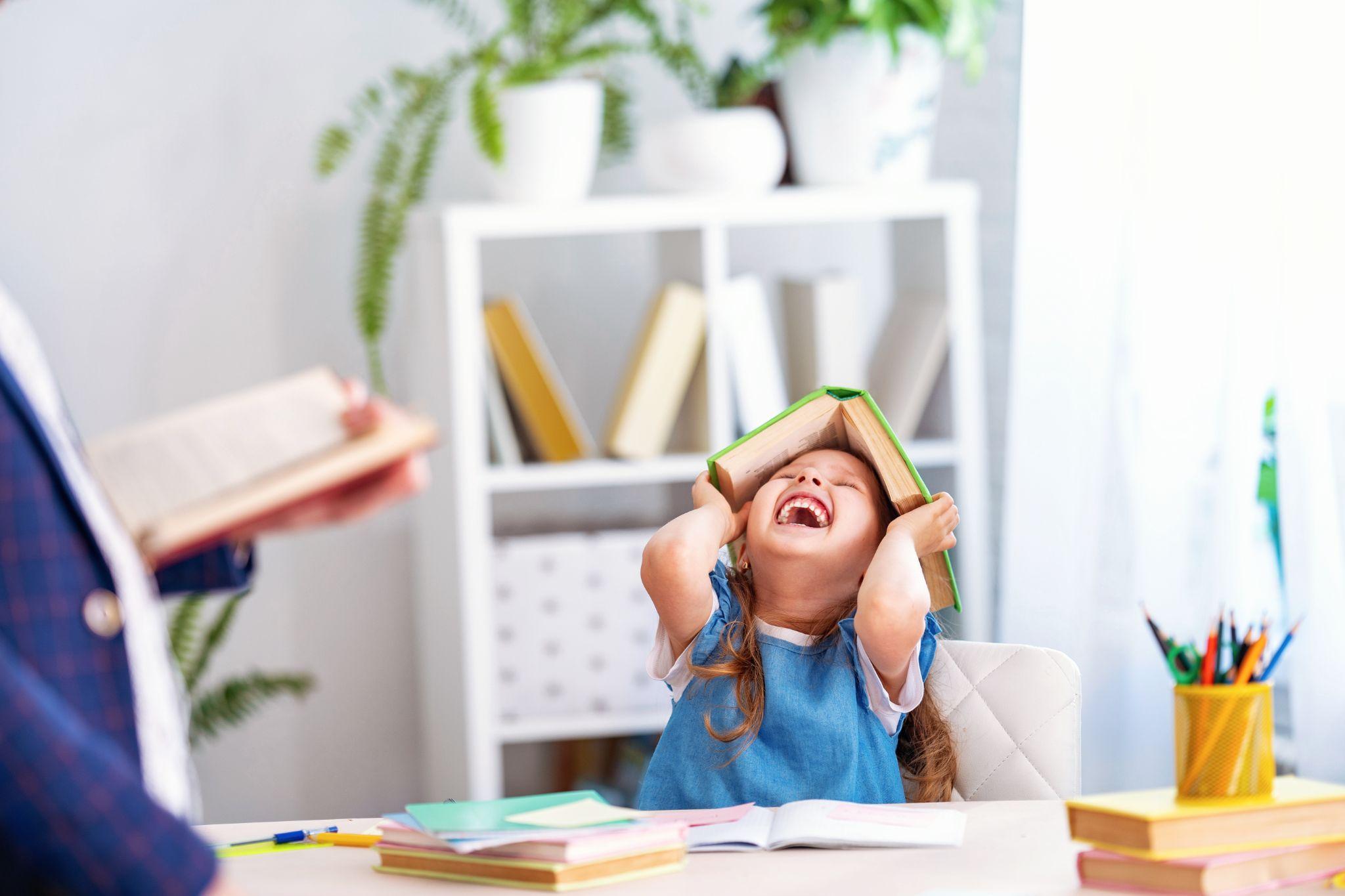 young-girl-laughing-with-book-on-head